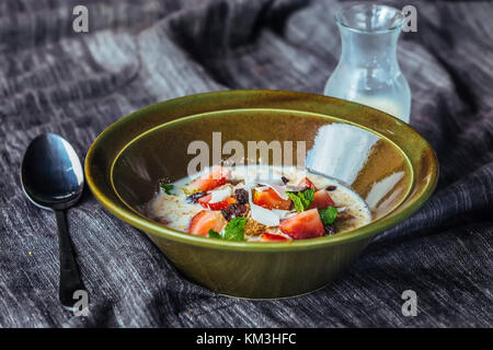 Granola. granola con il latte e le bacche sul tavolo. Foto Stock