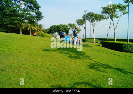 Le persone sono rilassanti sul prato della Baia di Shenzhen park. A shenzhen, Cina. Foto Stock