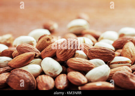 Almond miscelati su sfondo di legno. Foto Stock