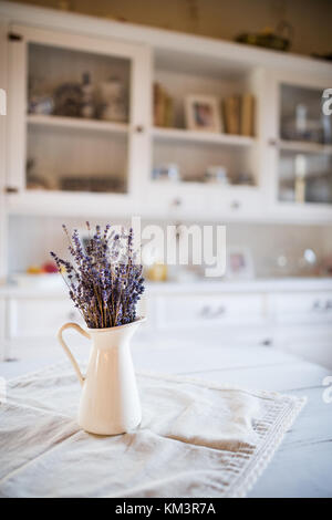 Lavanda essiccata mazzetto in un vaso bianco in cucina vintage. Foto Stock