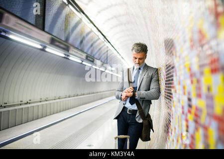 Imprenditore maturo in attesa su una stazione della metropolitana. Foto Stock