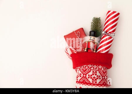 Calza di Natale con cracker, giocattolo e avvolti presente Foto Stock