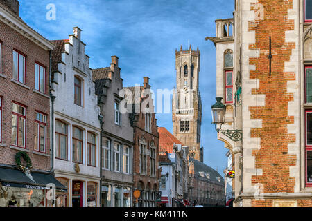 Tipica architettura di Bruges e negozio di fronti con cioccolato e negozi di pizzo, il 83 metri di un alto campanile in Markt (piazza del mercato) Foto Stock