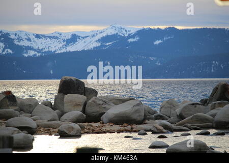 Rocce seduto di fronte alla grande montagna. Foto Stock