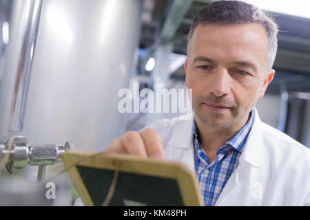 Scienziato caucasici in tuta checingk letture della macchina Foto Stock