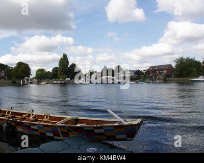 Arlecchino dipinto di barca a remi sulla riva del fiume Tamigi a Weybridge, Surrey, England, Regno Unito Foto Stock