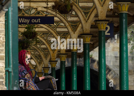 Ragazza adolescente nel cranio facepaint attesa per il treno a Knaresborough stazione ferroviaria, Yorkshire. Ottobre 2017. Foto Stock