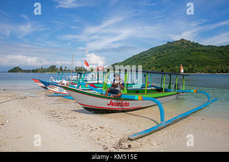 Indonesiano guida turistica la riproduzione di ukulele sulla barca outrigger sull'isolotto gili nanggu, isole Gili, Isola di Lombok, Lesser Sunda islands, INDONESIA Foto Stock