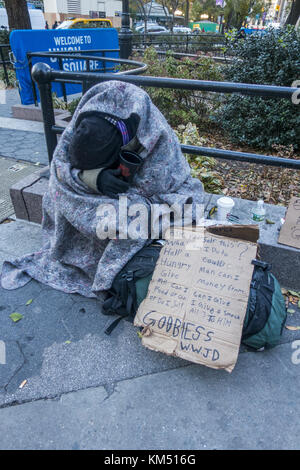 Senzatetto usurati uomo con segno mendica per soldi e cibo a Union Square a Manhattan, New York City. Foto Stock