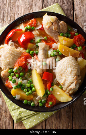 Afritada filippini: fette di pollo con verdure close-up in una ciotola sul tavolo. verticale in alto vista da sopra Foto Stock