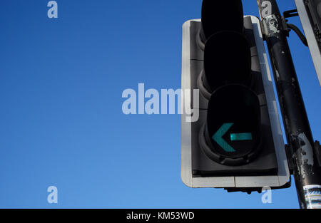 Semaforo verde con la freccia indicatore di direzione per svolta a sinistra contro il cielo blu che può essere utilizzato per molti concetti visivi. Foto Stock