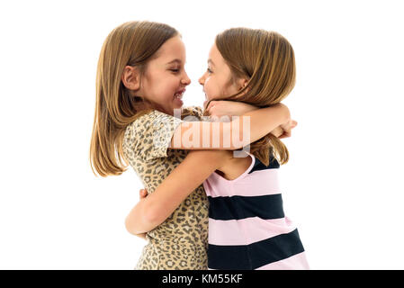 Gemello ragazze stanno cercando in ogni altro e sorridente. concetto di famiglia e sisterly amore. profilo vista laterale delle sorelle giocando, avvolgente, smilin Foto Stock