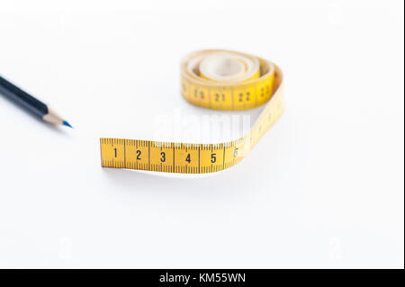 metro a nastro e penna su superficie bianca Foto Stock