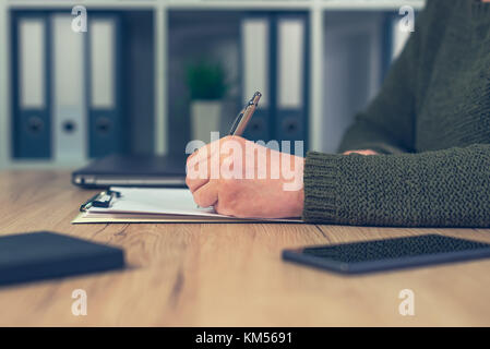 Femmina persona business scrivere appunti su carta per appunti in ufficio Foto Stock