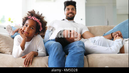 Giovane ragazza a guardare la tv con i suoi genitori Foto Stock