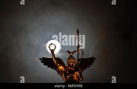 Berlino, Germania. 4 dicembre 2017. La luna che splende dietro Victoria sulla colonna della Vittoria a Berlino, Germania, 4 dicembre 2017. Crediti: Paul Zinken/dpa/Alamy Live News Foto Stock