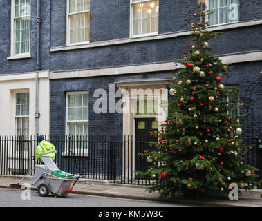 A Downing Street LONDRA, REGNO UNITO. 5 Dic, 2017. un consiglio di Westminster il detergente in Downing street passeggiate passato l'albero di natale. Credito: dinendra haria/alamy live news Foto Stock