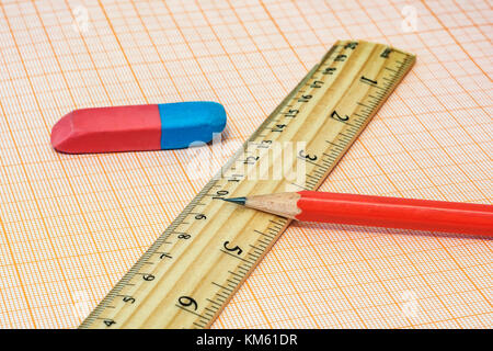 In millimetri di carta si trovano una gomma con un righello e un semplice matita close-up Foto Stock