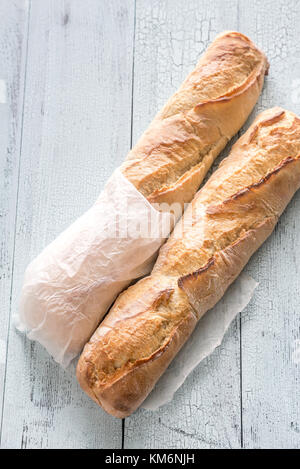 Due baguette sullo sfondo di legno Foto Stock