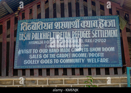 Pokhara, Nepal - 06 ottobre 2017: informative segno dei rifugiati tibetani settlemente scritto su un materiale metallico vecchie e arrugginite struttura in pokhara, Nepal Foto Stock
