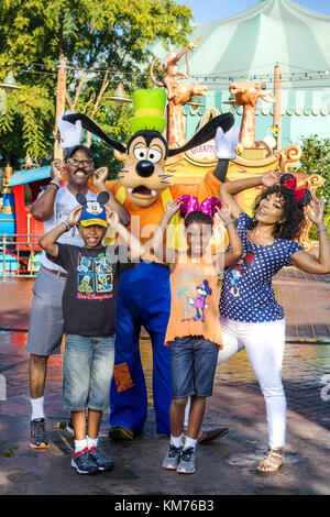 LAKE BUENA VISTA, FL: Attori Angela Bassett (destra) e Courtney B. Vance (sinistra) colpiscono una posa Giugno 19, 2015 Con Pippo lungo con loro gemelli Slater (anteriore sinistro) e Bronwyn (anteriore destro) al Magic Kingdom Park in Lake Buena Vista, Fla. la famiglia ha visitato il parco a tema durante il periodo di vacanza presso il Walt Disney World Resort. presso il Walt Disney World Resort in Lake Buena Vista, Florida. Persone: Angela Bassett e Courtney B. Vance visitare Disney World in Florida Foto Stock