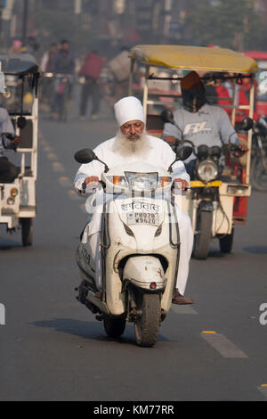 Punjabi uomo musulmano con una lunga barba bianca rides scooter di Amritsar, India Foto Stock