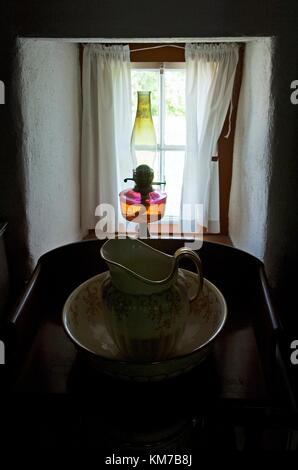 Ulster Folk and Transport Museum, Cultra, vicino a Belfast. Lavabo e lampada ad olio sul davanzale della camera da letto nella Vecchia Rettoria Foto Stock