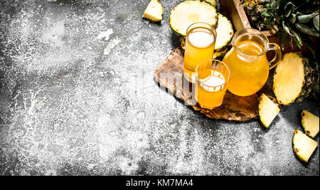 Spremuta di succo di ananas. su sfondo rustico. Foto Stock