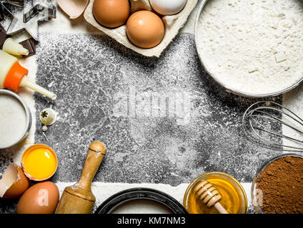 Sfondo di cottura. vari ingredienti per preparare deliziosi biscotti. su sfondo rustico. Foto Stock