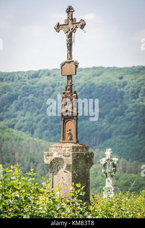 Vecchia croce arrugginita su un cimitero abbandonato vicino al castello in rovina in ex villaggio di Chervonohorod nella regione di Zalischyky, provincia di Ternopil, Ucraina Foto Stock