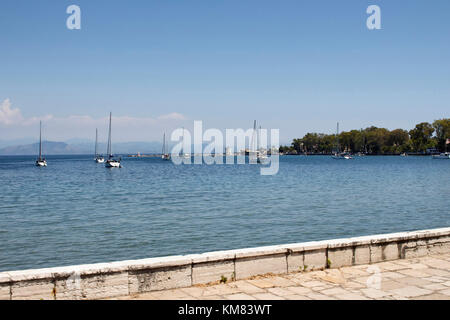 Vista di yachts in una baia di Corfù (Corfu). è un isola della Grecia a nord-ovest della costa del mar Ionio e il suo patrimonio culturale riflette anni trascorsi Foto Stock