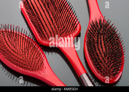 Tre rossi spazzole per capelli Foto Stock