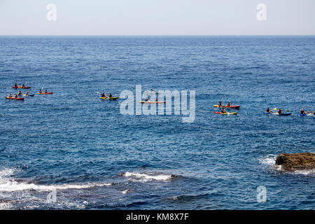 Molte persone ride kayaks di acqua nella parte anteriore del paese vecchio di Dubrovnik in blu mare mediterraneo in estate. Foto Stock