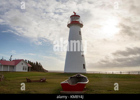 Faro al punto Prim con canotto in legno su Prince Edward Island, Canada contro nuvolosi cieli blu sulla giornata di sole. Foto Stock