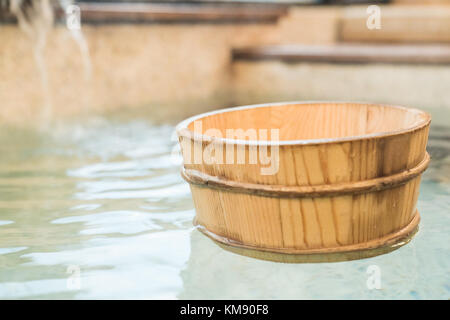 Barile di legno scoop galleggiante sull'acqua di sorgente calda in Giappone Foto Stock