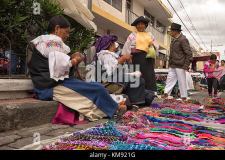 Otavalo, Ecuador - 2 Dicembre 2017: primo piano di una donna indigena venditore a vendere i doni fatti a mano nel sabato outdoor botteghe artigiane e di mercato agricolo Foto Stock