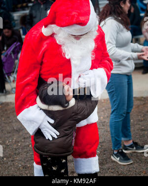 Un bambino saluta con impazienza Babbo Natale mentre esce dalla zona di goccia durante la 20esima operazione annuale Randy Oler Memorial Toy Drop, ospitato da U.S. Army Civil Affairs e Psychological Operations Command (Airborne), 2 dicembre 2017. Operazione Toy Drop è la più grande operazione combinata aerea del mondo con la partecipazione di otto paracadutisti nazionali partner e consente ai soldati di allenarsi sulla loro specialità militare professionale, mantenere la loro disponibilità aerea, e restituire alla comunità locale. Foto Stock