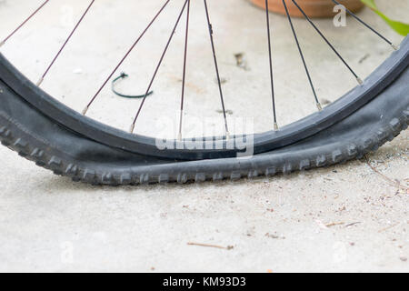 Vista ingrandita del piatto di bicicletta pneumatico sul marciapiede. Foto Stock