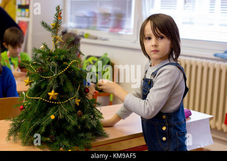 Primo grado boy a scuola per la preparazione di articoli fatti a mano per Natale mostra la scuola Foto Stock