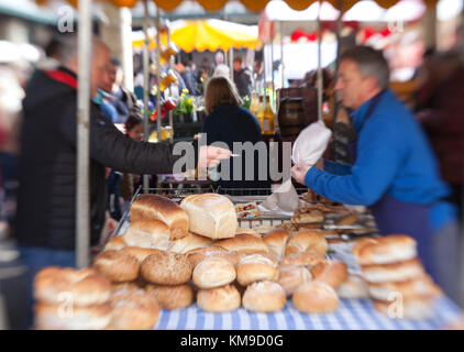 Un uomo acquista pane artigianale da una bancarella presso il pluripremiato mercato agricolo di Stroud nel Gloucestershire, Regno Unito Foto Stock