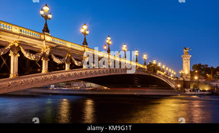 Vista panoramica del Pont Alexandre III bridge illuminato di sera con il Fiume Senna. Ottavo Arrondissement, Parigi, Francia Foto Stock