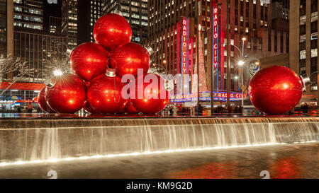 Rossa gigante ornamenti di Natale sulla 6th Avenue con la stagione delle feste decorazioni. Midtown. La città di New York Foto Stock