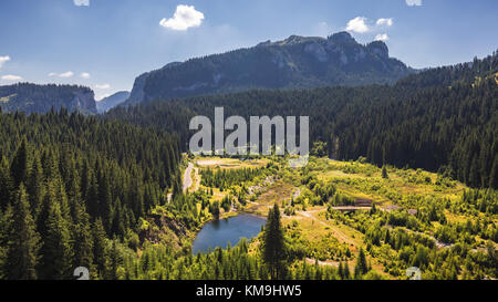 Vista lago Bolboci dal leggermente umido con le montagne dei Carpazi in background, Sinaia, Romania. Foto Stock