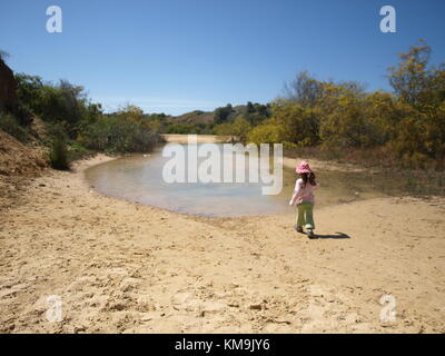 La ragazza che si avvicinano ad un piccolo lago su una duna di sabbia vicino al mare Foto Stock