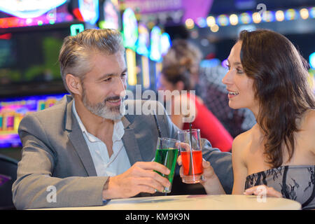 Giovane celebra nel casino con coktails Foto Stock