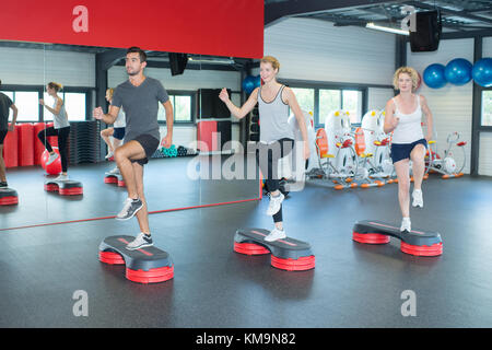 Le persone felici facendo indoor bike in un fitness club Foto Stock