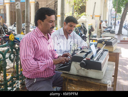 Street dattilografa e i clienti che cercano i loro documenti sul sentiero a Mysore, mysuru, Karnataka, India. Foto Stock