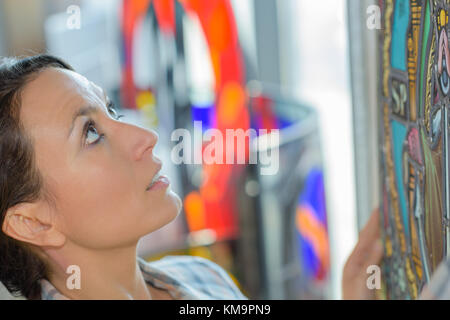 Donna mettendo illustrazione in alto sulla parete Foto Stock