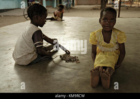 Due bambini che giocavano un gioco con pietre in Kawaza village, Provincia Orientale, Zambia Foto Stock