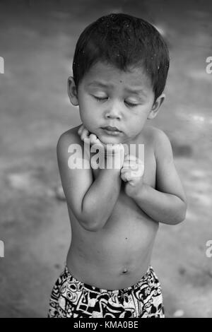 Shy piccolo ragazzo, Ta Chet villaggio, Somroang Yea comune, Puok distretto, Siem Reap Provincia, Cambogia: Versione in bianco e nero. Foto Stock